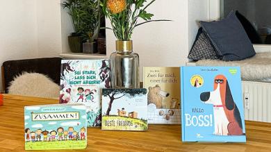 
		Selected books are presented on a table with a vase of flowers in the background.
	